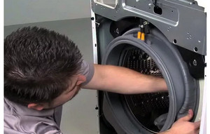 Мастер осуществляет замену резинки стиральной машины